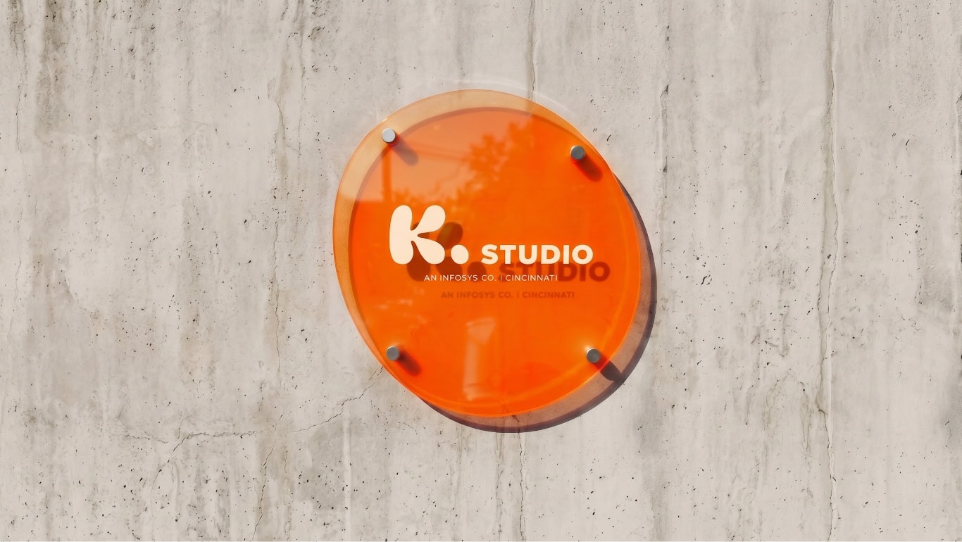 Orange K. Studio sign mounted on a concrete wall