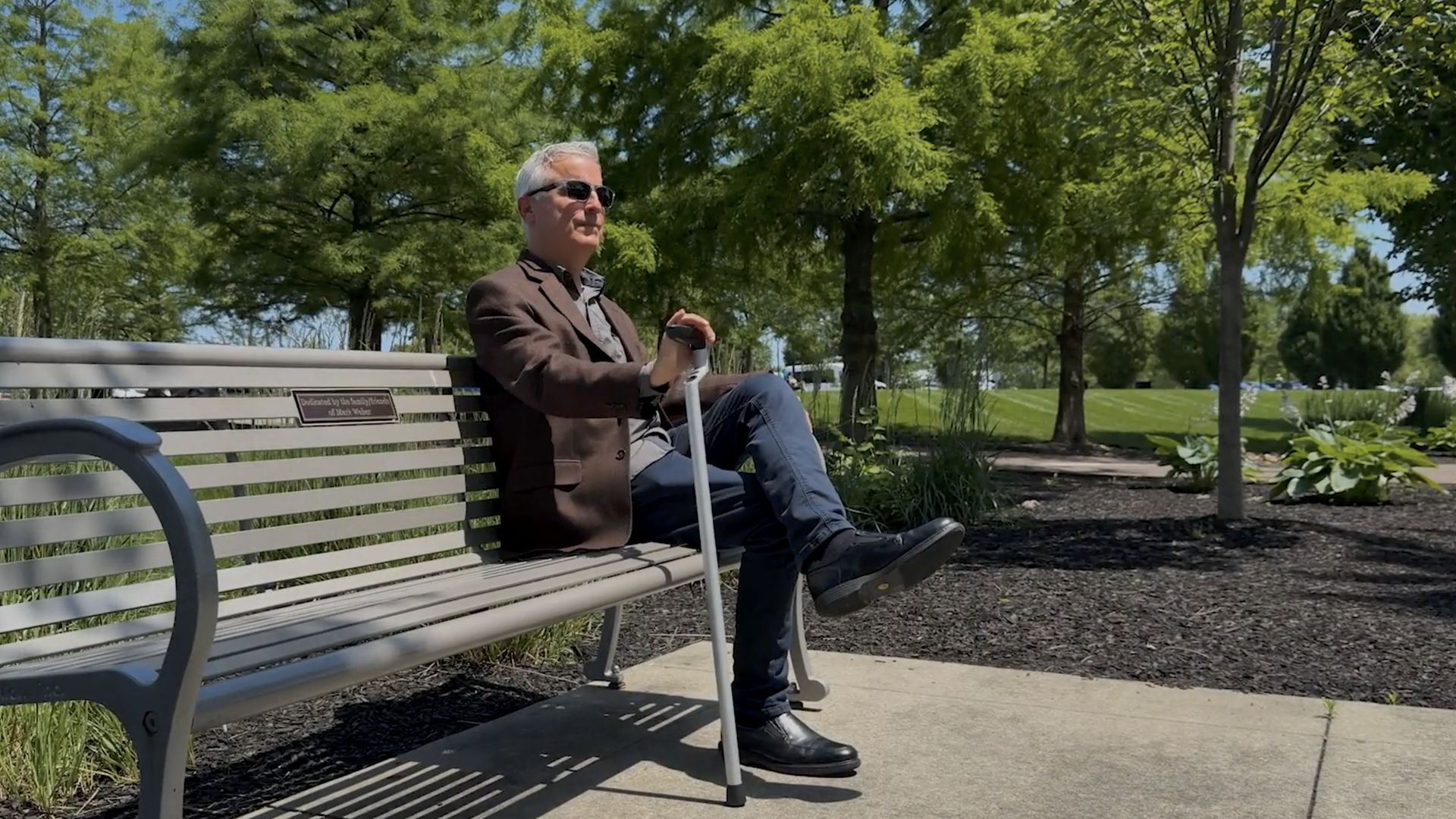 Man sitting on a park bench with the Columbo mobility aid