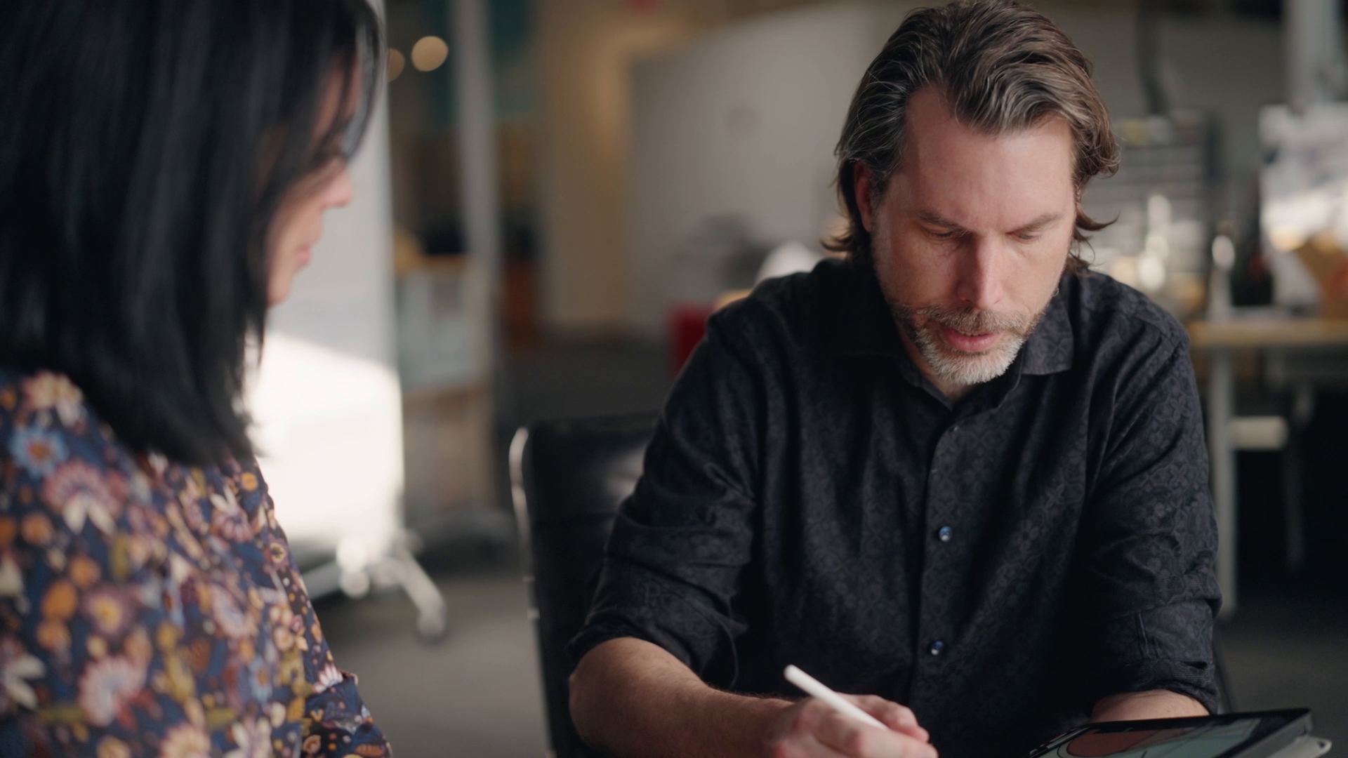 Kaleidoscope designer sketching on a tablet beside a colleague