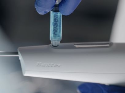 Gloved hand loading a vial into a Baxter laparoscopic applicator