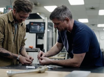 Two engineers assembling a small medical device at a lab bench